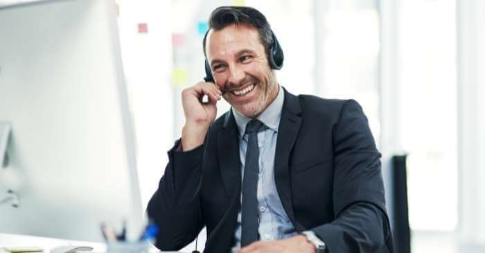 homem com roupas sociais sorrindo enquanto fala no telefone, representando o conceito de sucesso com o método primeira venda
