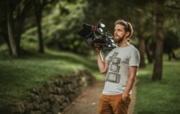 man in gray crew neck t-shirt and brown pants holding black dslr camera